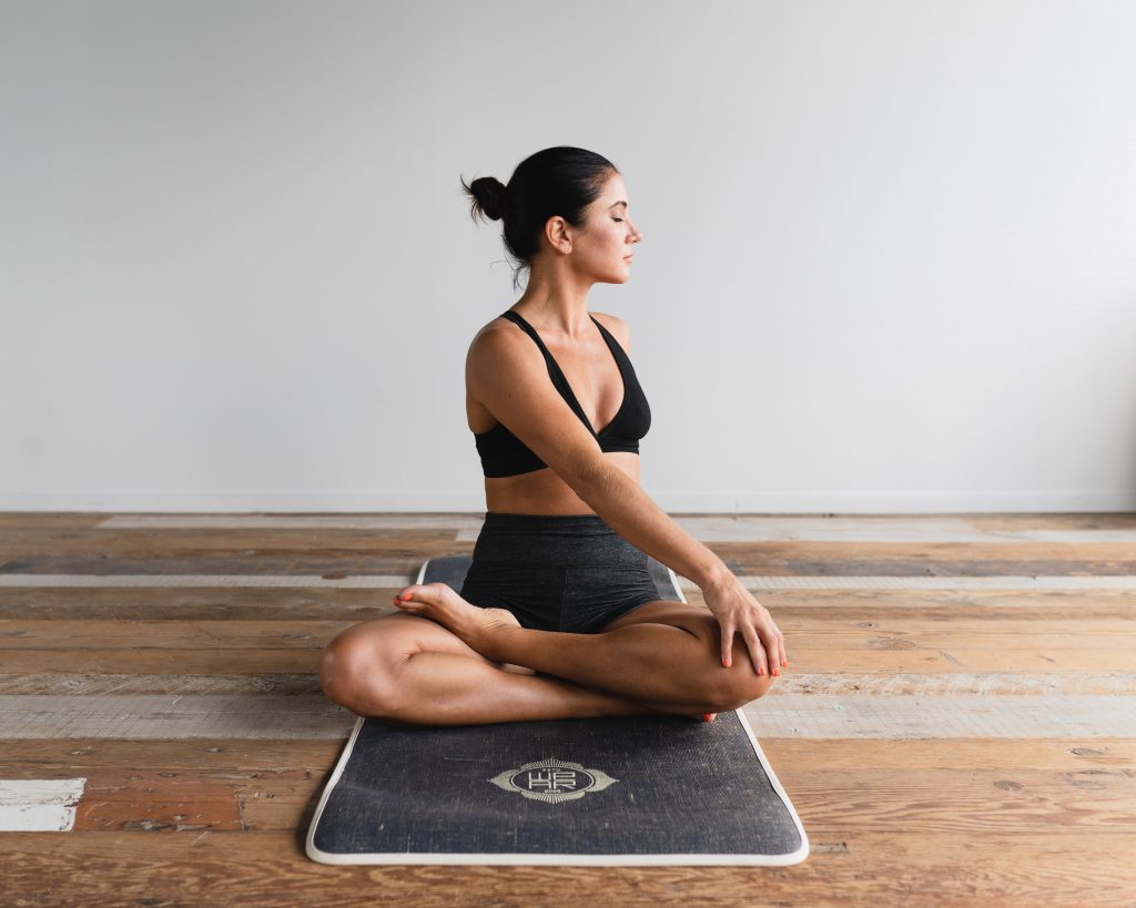 Woman practicing yoga to reduce stress. 